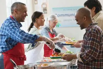 Voluntari care servesc mâncare la bucătăria comunității