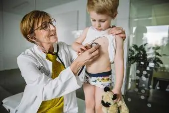 Mjeku që ekzaminon djalin e vogël me stetoskop