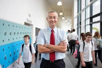 Férfi tanár portréja karba tett kézzel az iskola folyosóján