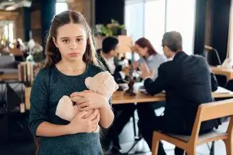 Une fille triste se tient avec un ours dans un bureau d'avocat