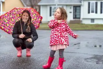 Mère et fille s'amusant sous la pluie