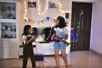 Kanak-kanak perempuan membuat persembahan lagu di rumah