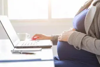 հղի կինն աշխատում է համակարգչի նոութբուքի վրա