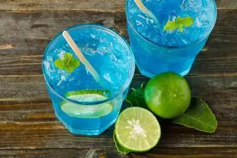 Blaue Margarita mit Limette auf Holzhintergrund
