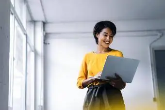 امرأة مبتسمة تستخدم الكمبيوتر المحمول