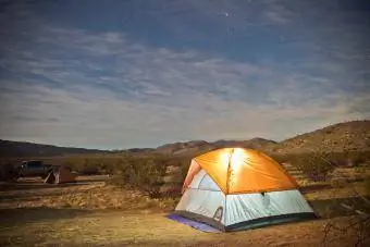tente rougeoyante sous le ciel nocturne du désert