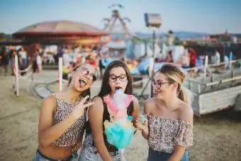 Mädchen essen Zuckerwatte auf dem Jahrmarkt