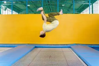 ילד מתבגר קופץ בפארק טרמפולינה במרכז ספורט