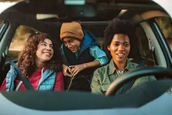 Familje e lumtur duke shijuar kohën e tyre në një makinë