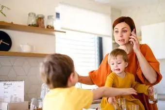 stressaantunut äiti keittiössä lasten kanssa