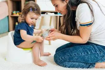 mère lisant un livre à un enfant apprenant la propreté