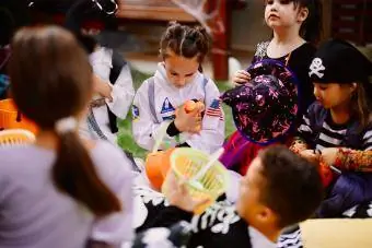 Хүүхдүүд арын цэцэрлэгт хүрээлэнгийн үдэшлэгт Halloween тоглоом тоглож байна