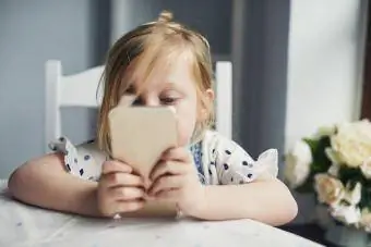 Ухаалаг утас хэрэглэж буй бяцхан охин