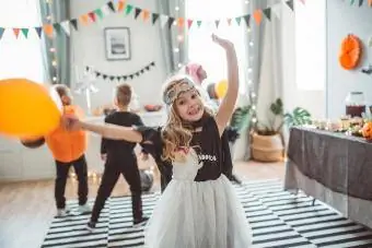 dievča v kostýme tancuje na rodinnej halloweenskej párty
