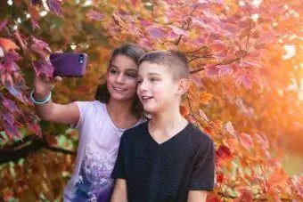 māsa un brālis uzņem selfiju ar rudens tēmu