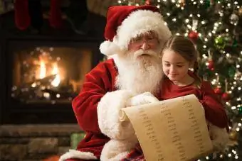 Lista de lectura de Papá Noel con niña en Navidad