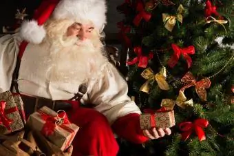 le père Noël livre des cadeaux sous l'arbre