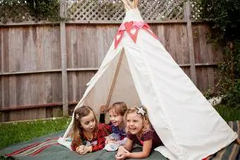 Los niños pequeños en tienda de campaña acampando en el patio trasero