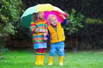 småbarn under ett paraply i regn