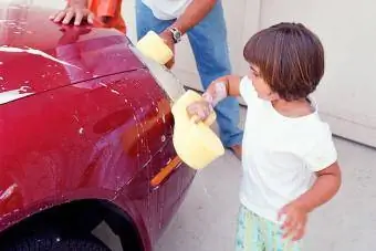 Niña pequeña lavando el coche