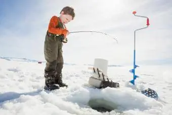 Chłopiec łowiący ryby pod lodem
