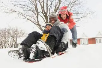 Família negra andando de trenó na neve