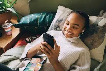 Nasmejano dekle uporablja pametni telefon