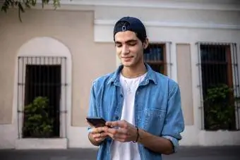 Najstnik uporablja mobilni telefon na prostem