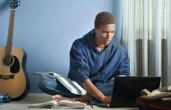 remaja membuat kerja rumah dengan komputer riba
