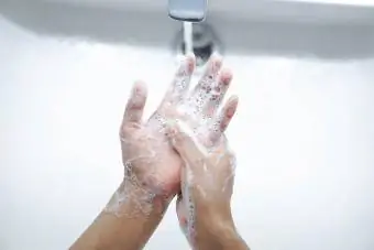 Гараа савангаар угааж байгаа хүн