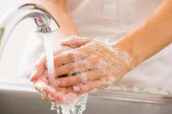 Persona che risciacqua il sapone dalle mani