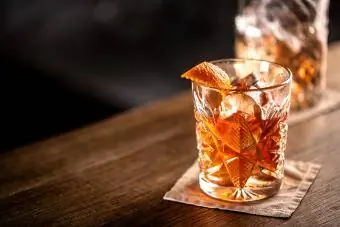 Minuman wiski labu kuno di atas es dengan hiasan kulit jeruk