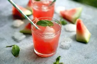 Wassermelonen-Martini mit Papierstrohhalmen, Minzblättern und Eis