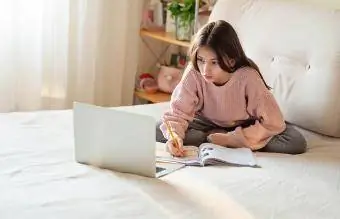 Paauglė mergina atlieka namų darbus