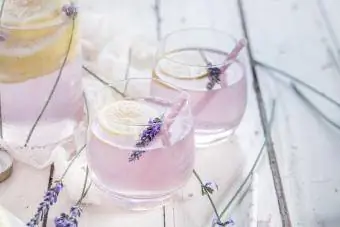 Gin cytrynowo-lawendowy w szklance ze słomką do picia