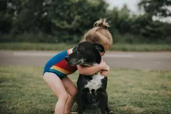 دختر سگ را در آغوش می گیرد