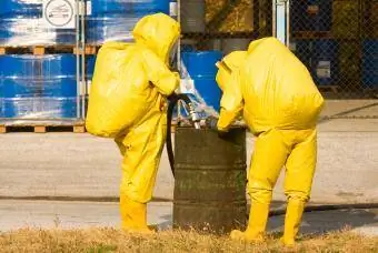 Хора в жълти костюми, събиращи опасни материали