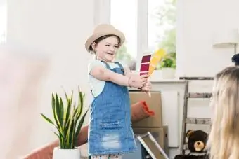 Meisje dat kleurmonster toont aan ouders in een nieuw huis