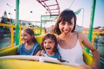 Petit fils et fille avec leur mère sur des montagnes russes