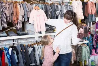 Família escolhe roupas para recém-nascidos