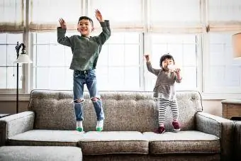 Kinder springen zu Hause auf die Couch