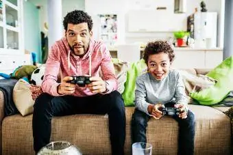 Vater und Sohn konzentrieren sich beim gemeinsamen Spielen von Videospielen