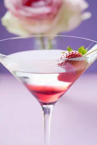 Martini à la fraise en verre, rose en arrière-plan