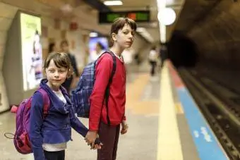 Fëmijë që presin në stacionin hekurudhor