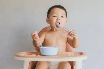 tek başına yemek yiyen erkek bebek