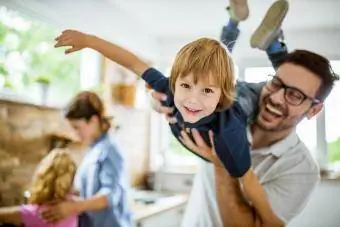 Gelukkige jongen die plezier heeft met zijn vader in de keuken