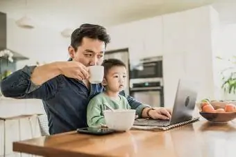 Аав хүүхэдтэйгээ зөөврийн компьютер ашиглаж байна