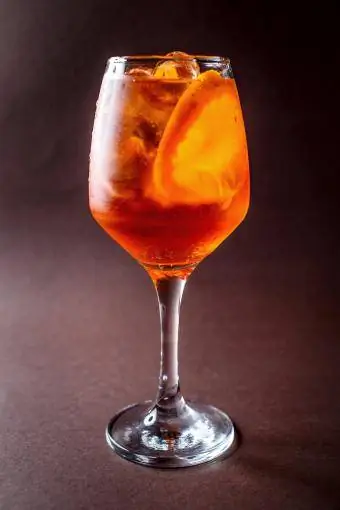 Glas Spritz mit Orange auf elegantem dunkelbraunem Hintergrund