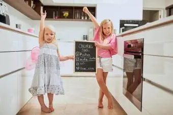 دو دختر کوچولو که نمودار کارهای روزمره را در دست دارند