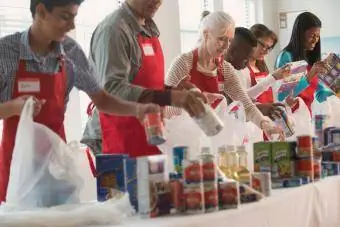 Voluntari care împachetează conserve la colectarea de alimente